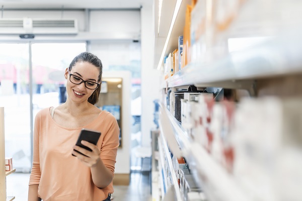 A woman using her phone in a pharmacy