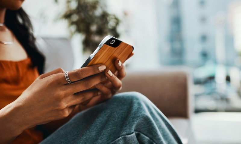 A student using their phone while sitting on a couch