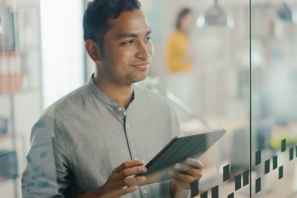 A student smiling, using an iPad